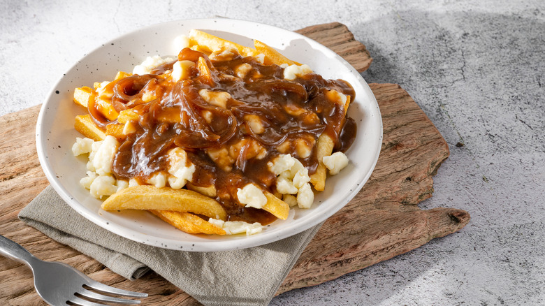 Bowl of poutine with brown gravy and cheese curds