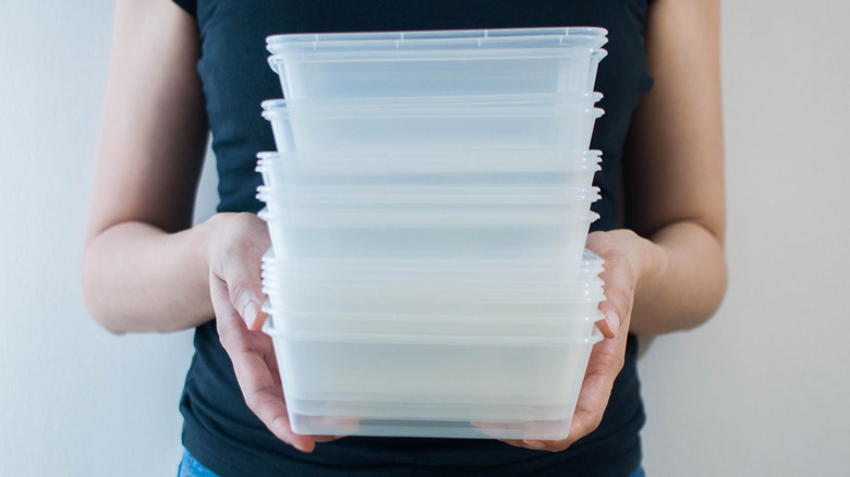 Woman holding plastic food containers