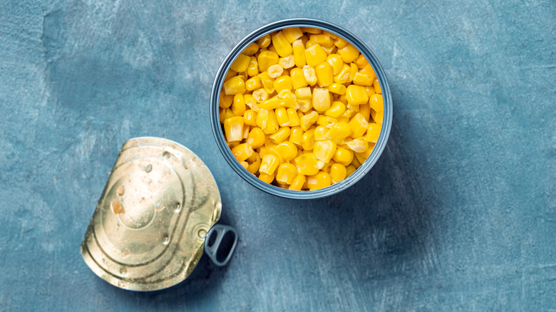 canned corn on a blue surface