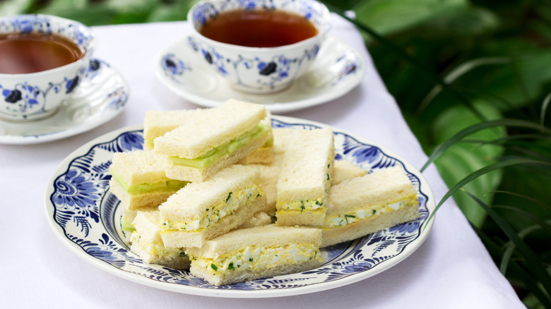 Egg salad tea sandwiches with cups of tea