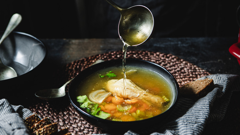 Chicken soup being poured into a bowl