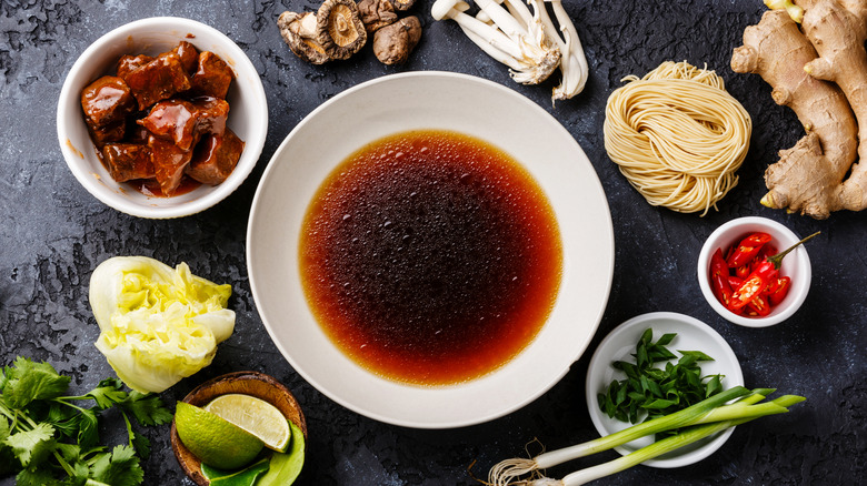 Ingredients surrounding a bowl of ramen broth