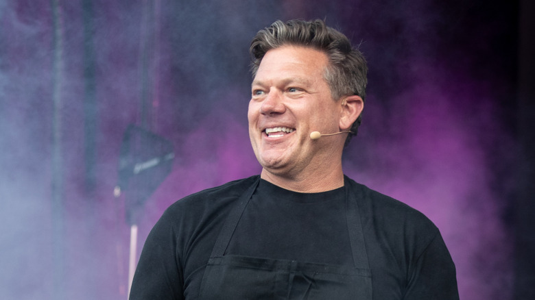 Tyler Florence smiling at an event with a microphone