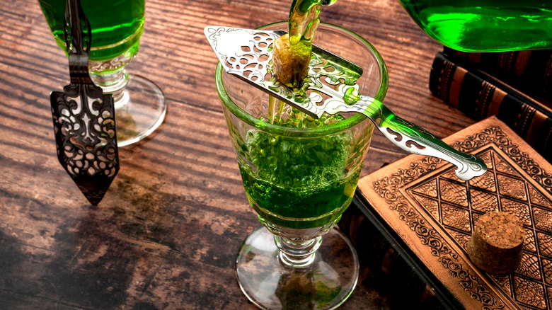 Absinthe being poured over glass with sugar cube