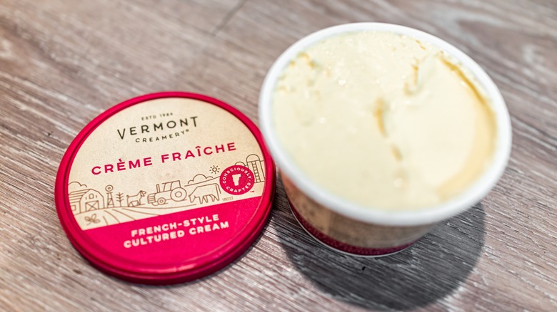 Crème fraîche container on wood table