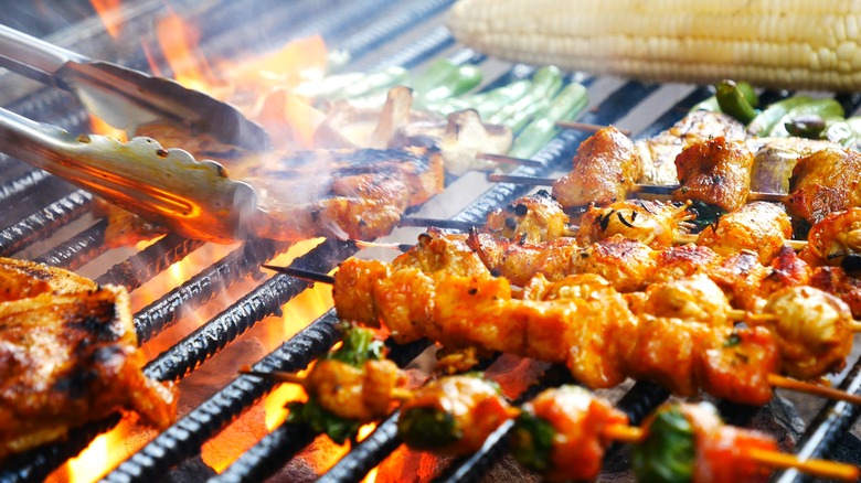 backyard grill with different types of meats cooking