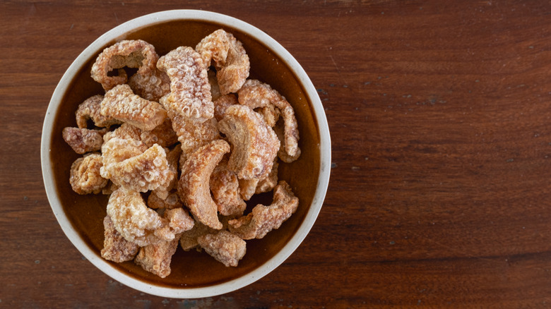 A plate of crispy pork rinds sitting on a table