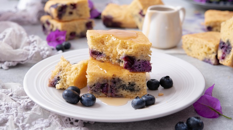 Cornbread on plate with blueberries and honey