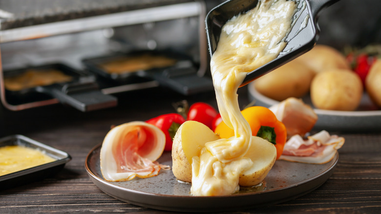 Pouring raclette cheese onto vegetables