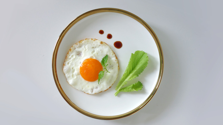 Sunny side up egg with sauce and lettuce