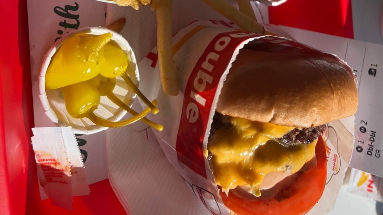 pickled peppers served beside an In-N-Out cheeseburger