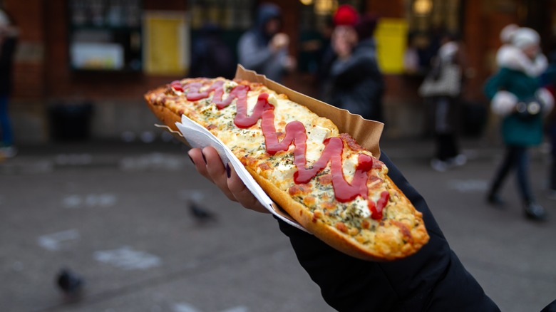 Hand holding a Polish zapiekanka