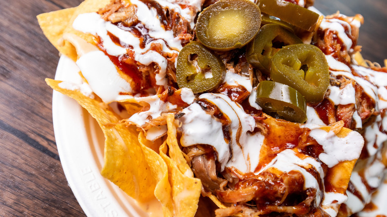 Pulled pork nachos on a paper plate