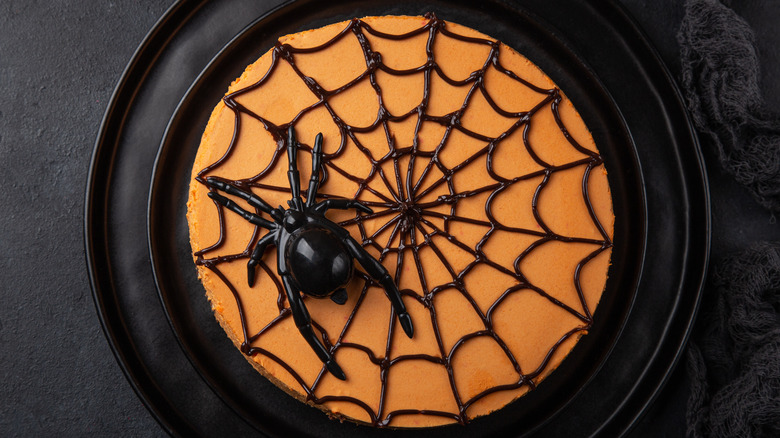 Orange cheesecake with spider decoration