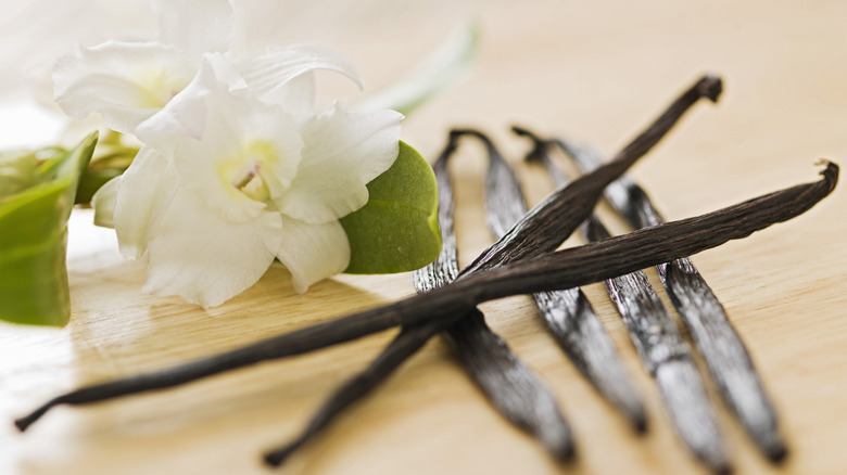 Vanilla pods, with their flowers on a table.