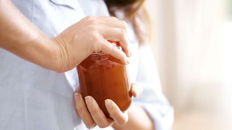 Person trying to open a stubborn jar