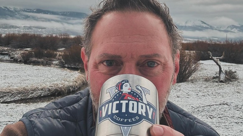 Victory Coffees founder Cade Courtley drinking a branded cup of coffee outdoors