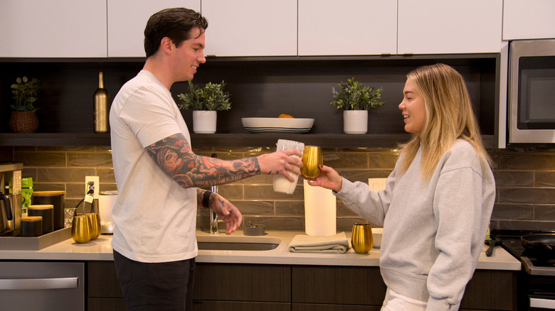 Person blending a smoothie with banana and avocado.