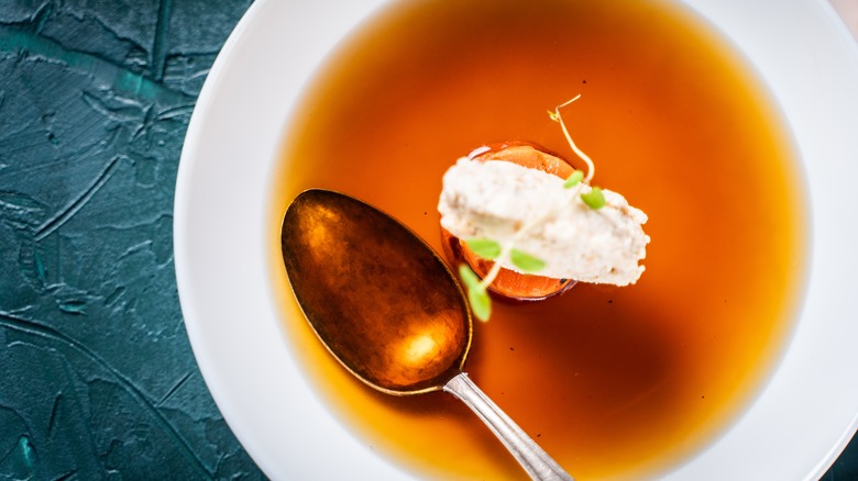 Meat consommé in a small white bowl