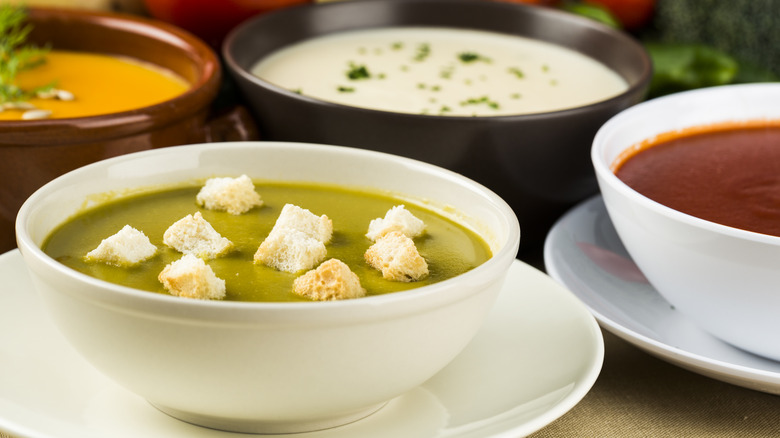 Assorted soups on a table in various colors