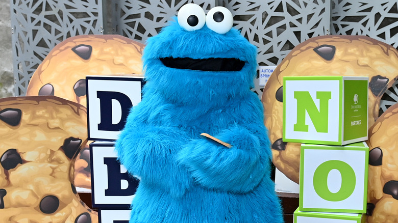 Cookie Monster in front of large cookie cutouts