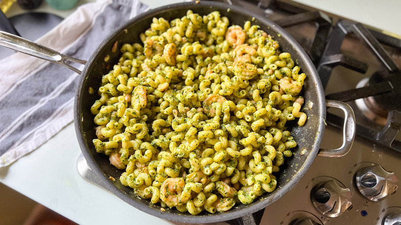 Walnut pesto pasta with shrimp in pan on stove