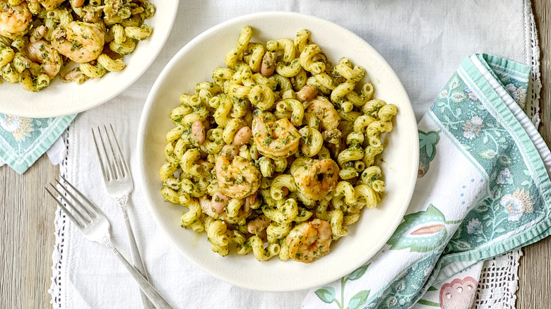 Walnut pesto pasta with shrimp in bowls on table