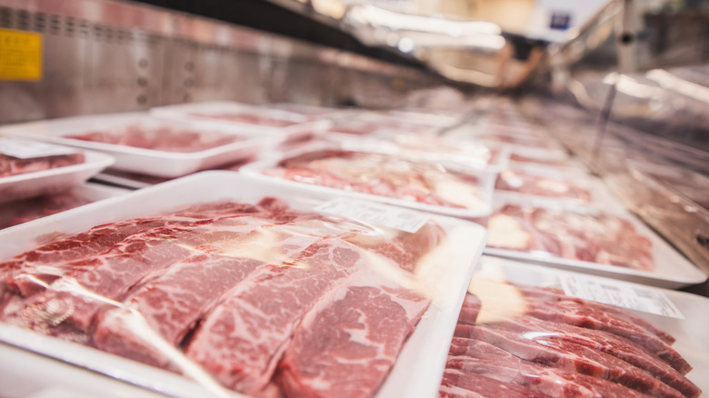 Packages of well-marbled red meat in a grocery store's cooler