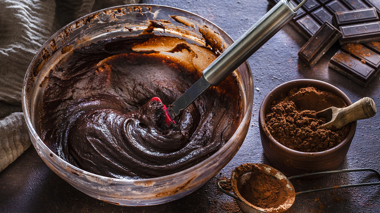 brownie mix in a glass bowl alongside cocoa powder