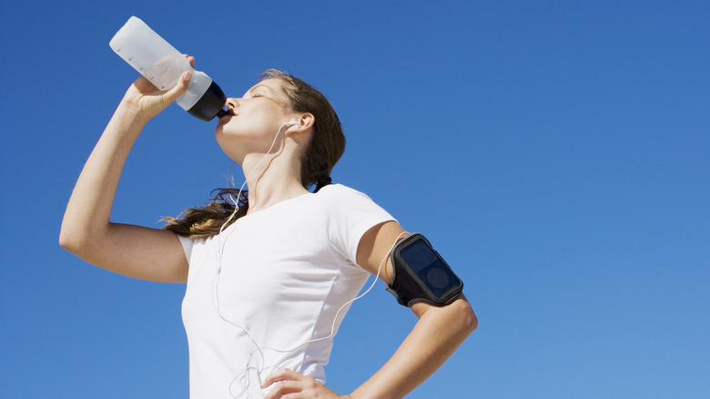 woman drinking from water bottle