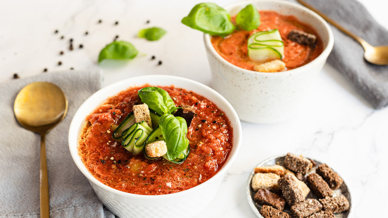 Two bowls of soup with spoons and garnish