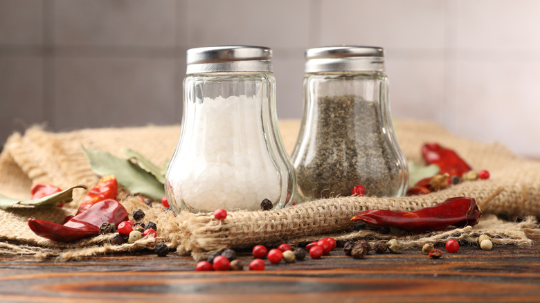 salt and pepper shakes surrounded by chiles