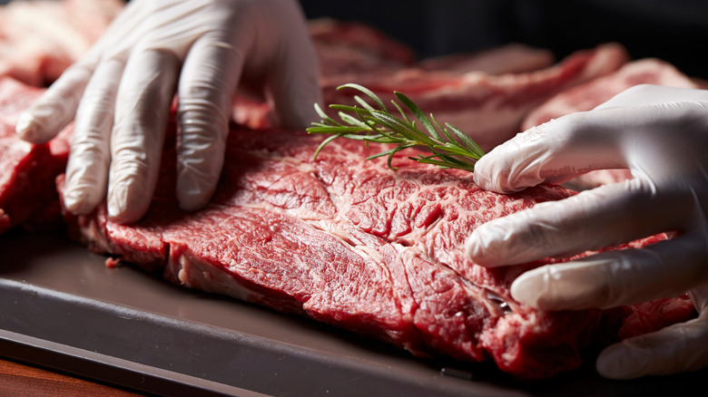 butcher or chef handling raw beef