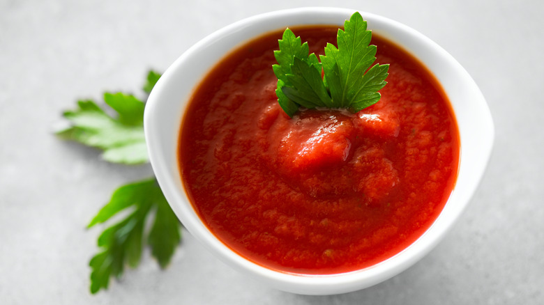 bowl of red pasta sauce with herb garnish