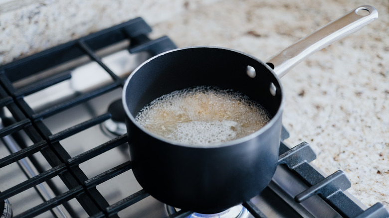 Pot of rice cooking in water on a stove