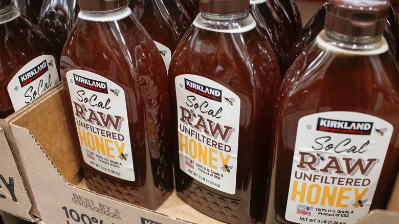 Bottles of Kirkland Signature Raw Unfiltered Honey on display at Costco.