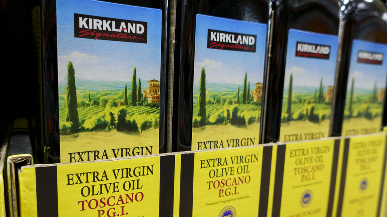 Bottles of Kirkland Signature Extra Virgin Olive Oil on display at a Costco warehouse