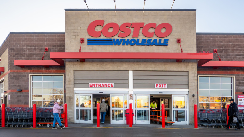 Exterior of a Costco store with shopping carts and people out front