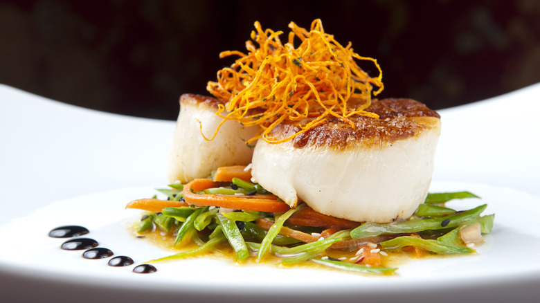 closeup of caramelized scallop with fancy topping