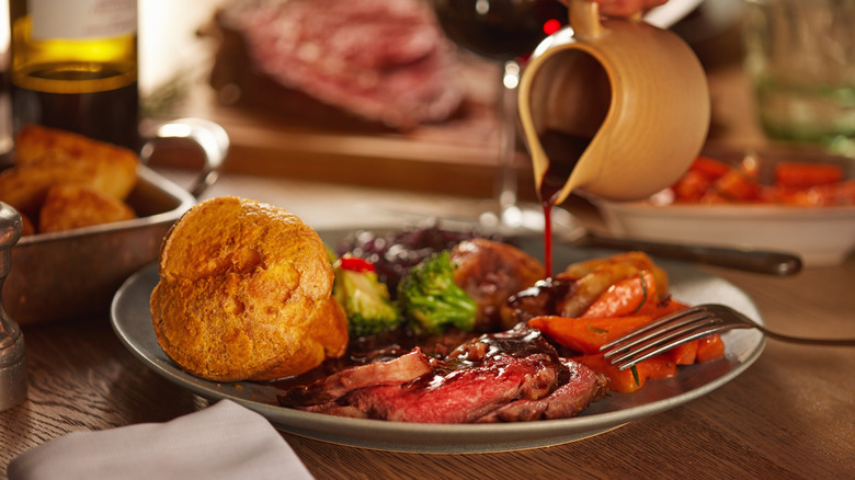 Gravy being poured onto a Sunday roast.