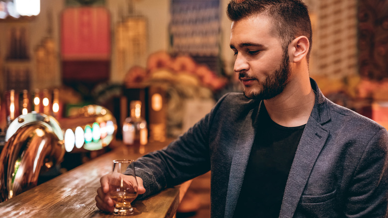 person drinking whiskey in bar