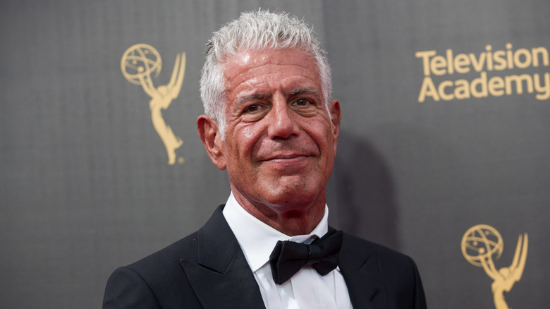 Anthony Bourdain smiles slightly on an Emmy's red carpet