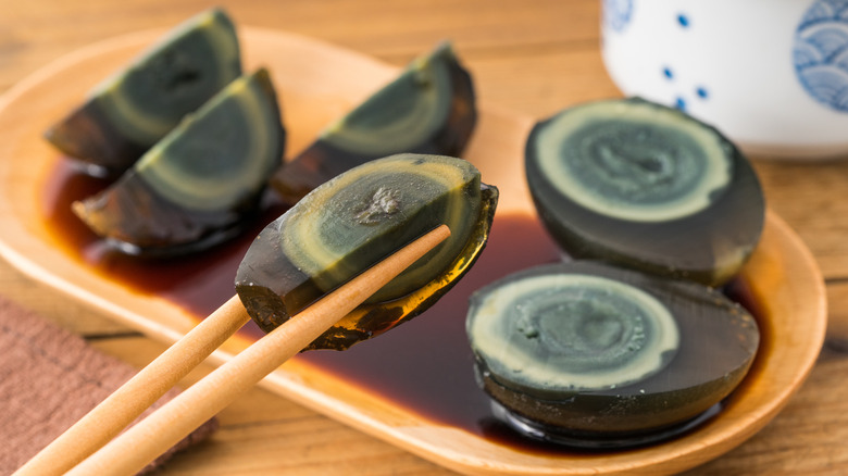 Century eggs in chopsticks