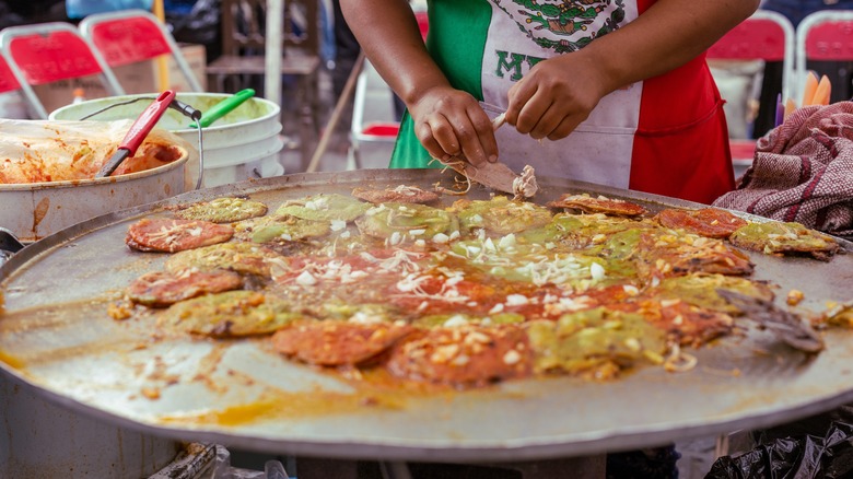 woman preparing chalupas on round grill