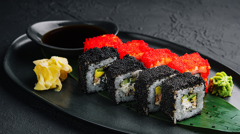 A plate of sushi with red and black tobiko fish roe