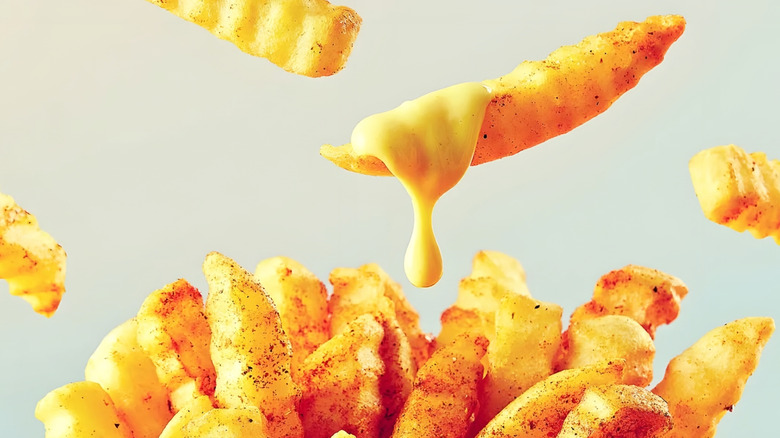 Cheese sauce dripping from fries.