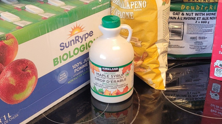A jug of Costco maple syrup sits among other Costco purchases on a stove