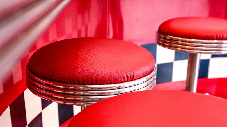 A row of red vinyl 1950s bar stools