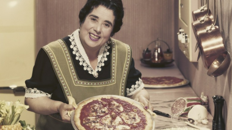 Vintage 1950s photo of a woman showing off a homemade pizza