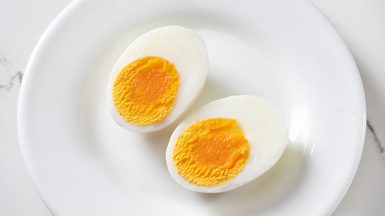 A just-set hardboiled egg split open on a white plate
